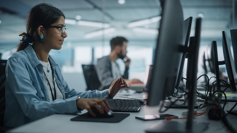 Young female engineer working at a laptop, coding
